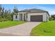 New home with a paved driveway, manicured lawn, and a two-car garage at 8105 Antwerp Cir, Port Charlotte, FL 33981