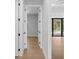 Hallway view leading to an open living area and pool showcasing wood-look floors and white trim at 8105 Antwerp Cir, Port Charlotte, FL 33981