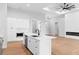 A large kitchen with white cabinetry, a center island, and views of the living room at 8105 Antwerp Cir, Port Charlotte, FL 33981