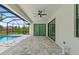 Covered patio featuring brick floors and a ceiling fan next to screened-in pool at 8105 Antwerp Cir, Port Charlotte, FL 33981
