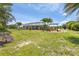 Large backyard with screened lanai, swing set, and mature palm trees at 8127 Consul St, Port Charlotte, FL 33981