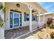 Inviting front porch with a blue front door, nautical shutters, and brick paver flooring at 8127 Consul St, Port Charlotte, FL 33981