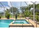 Screened pool and spa with lush landscaping offer a private outdoor retreat at 8127 Consul St, Port Charlotte, FL 33981