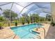 Inviting screened-in pool with a spa, surrounded by lush tropical landscaping at 8127 Consul St, Port Charlotte, FL 33981