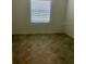 Empty bedroom featuring a window with blinds and neutral tile flooring at 8360 Waterscape Rd, Englewood, FL 34224