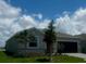 Charming single-story home with a modern exterior, well-manicured lawn, and inviting curb appeal under a bright blue sky at 8360 Waterscape Rd, Englewood, FL 34224