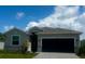 Charming single-story home with a modern exterior, well-manicured lawn, and inviting curb appeal under a bright blue sky at 8360 Waterscape Rd, Englewood, FL 34224