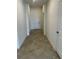 Hallway with neutral walls and tile flooring leading to a door at the end at 8360 Waterscape Rd, Englewood, FL 34224