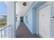Outdoor hallway featuring blue walls and a white entry door at 8405 Placida Rd # 406, Placida, FL 33946