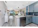 Open concept kitchen and living area, featuring blue cabinets, quartz countertops, and luxury vinyl flooring at 8405 Placida Rd # 406, Placida, FL 33946