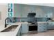 Modern kitchen with stainless steel appliances, quartz countertops, and blue backsplash at 8405 Placida Rd # 406, Placida, FL 33946