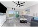 Bright living room with modern ceiling fan, slider doors to outdoor patio, and luxury vinyl plank flooring at 8405 Placida Rd # 406, Placida, FL 33946