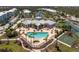 Aerial view of a community pool and amenity center surrounded by palm trees and greenery at 8405 Placida Rd # 406, Placida, FL 33946