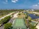 Community tennis court and surrounding greenery offer recreational opportunities at 8405 Placida Rd # 406, Placida, FL 33946