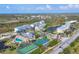 Panoramic aerial view of a neighborhood featuring multiple buildings, a pool, and tennis courts at 8411 Placida Rd # 404, Placida, FL 33946