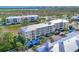 Aerial view of multi-story condominium complex with water views, mature palms and covered parking at 8411 Placida Rd # 404, Placida, FL 33946