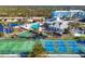 Aerial view of resort featuring pool, tennis courts, lush landscaping, and blue building at 8411 Placida Rd # 404, Placida, FL 33946