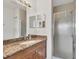 Well-lit bathroom showcasing a shower and a wood cabinet vanity with a granite countertop at 8411 Placida Rd # 404, Placida, FL 33946