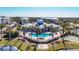 Beautiful community pool and clubhouse surrounded by palm trees and lush landscaping on a sunny day at 8411 Placida Rd # 404, Placida, FL 33946