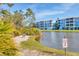 Scenic view of a building with a lake and nature walk featuring a bench and an alligator warning sign at 8411 Placida Rd # 404, Placida, FL 33946