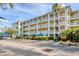 Exterior of condo building featuring covered parking, private balconies, and tropical plants at 8411 Placida Rd # 404, Placida, FL 33946