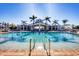 Resort-style pool with a view of the clubhouse, palm trees, and clear blue water at 8411 Placida Rd # 404, Placida, FL 33946
