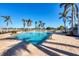 Sparkling community pool with palm trees and lounge chairs under a clear blue sky at 8411 Placida Rd # 404, Placida, FL 33946