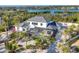 Aerial view of a white two story home, pool, screened in patio, gray roof and landscaped yard at 8500 Manasota Key Rd, Englewood, FL 34223