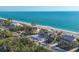 Breathtaking aerial view of a beachfront home with lush landscaping and stunning ocean views at 8500 Manasota Key Rd, Englewood, FL 34223