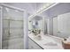 Bright bathroom with a shower-tub combo, single sink vanity, and large mirror at 8500 Manasota Key Rd, Englewood, FL 34223