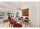 Dining area features a glass top table, chandelier, tile flooring, with natural light from the window at 8500 Manasota Key Rd, Englewood, FL 34223