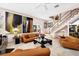 Stylish living room with leather furniture, elegant decor, and a staircase with brass railings at 8500 Manasota Key Rd, Englewood, FL 34223