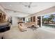Beautiful living room with tile floors, comfortable beige sectional, and sliding glass doors leading to the pool area at 8500 Manasota Key Rd, Englewood, FL 34223