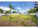 View of the large, grassy backyard with a white fence, highlighting the space and privacy of the property at 859 E 2Nd St, Englewood, FL 34223