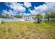 Wide view of the grassy backyard, highlighting the property's spaciousness and white privacy fence at 859 E 2Nd St, Englewood, FL 34223