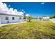 Expansive backyard with lush grass, a white house, and a storage shed, perfect for outdoor activities at 859 E 2Nd St, Englewood, FL 34223