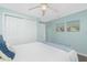 Serene bedroom with a closet, ceiling fan, coastal-themed art, and white linens at 859 E 2Nd St, Englewood, FL 34223