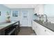 Bright eat-in kitchen featuring an island, gray countertops, white cabinets, and stainless steel appliances at 859 E 2Nd St, Englewood, FL 34223