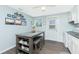 Charming eat-in kitchen with decor, table with seating, and a white door leading to the outside at 859 E 2Nd St, Englewood, FL 34223
