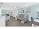 Open floor plan features living room flowing into the kitchen, with a ceiling fan and hardwood floors at 859 E 2Nd St, Englewood, FL 34223