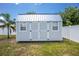 Backyard shed with double doors, offering ample storage and complementing the home's exterior at 859 E 2Nd St, Englewood, FL 34223