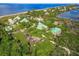 Picturesque aerial view of a beachfront property featuring multiple homes surrounded by lush greenery and stunning waterfront views at 9200 Little Gasparilla # 203, Placida, FL 33946