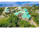 Aerial perspective of a beachfront home with multiple levels, decks, and lush greenery, offering serene coastal living at 9200 Little Gasparilla # 203, Placida, FL 33946