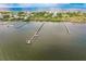 Panoramic aerial view of docks along the ocean near a village with lush green foliage at 9200 Little Gasparilla # 203, Placida, FL 33946