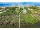 Stunning aerial view of a beachfront property with lush greenery and a private bridge leading to the main house at 9200 Little Gasparilla # 203, Placida, FL 33946