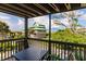 Balcony view with a table and chairs overlooking a grassy area and a multi-story home at 9200 Little Gasparilla # 203, Placida, FL 33946