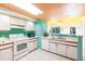 Bright, well lit kitchen with white appliances, colorful ceilings and a serving bar at 9200 Little Gasparilla # 203, Placida, FL 33946