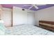 Bright bedroom with view of closet and entry door featuring a light purple ceiling and ceiling fan at 9200 Little Gasparilla # 203, Placida, FL 33946