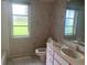 Modest bathroom featuring a toilet, sink with vanity, and two windows with exterior views at 1 Clubhouse Rd, Rotonda West, FL 33947