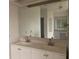 Bathroom vanity featuring double sinks, white cabinets, and a large mirror at 1 Clubhouse Rd, Rotonda West, FL 33947